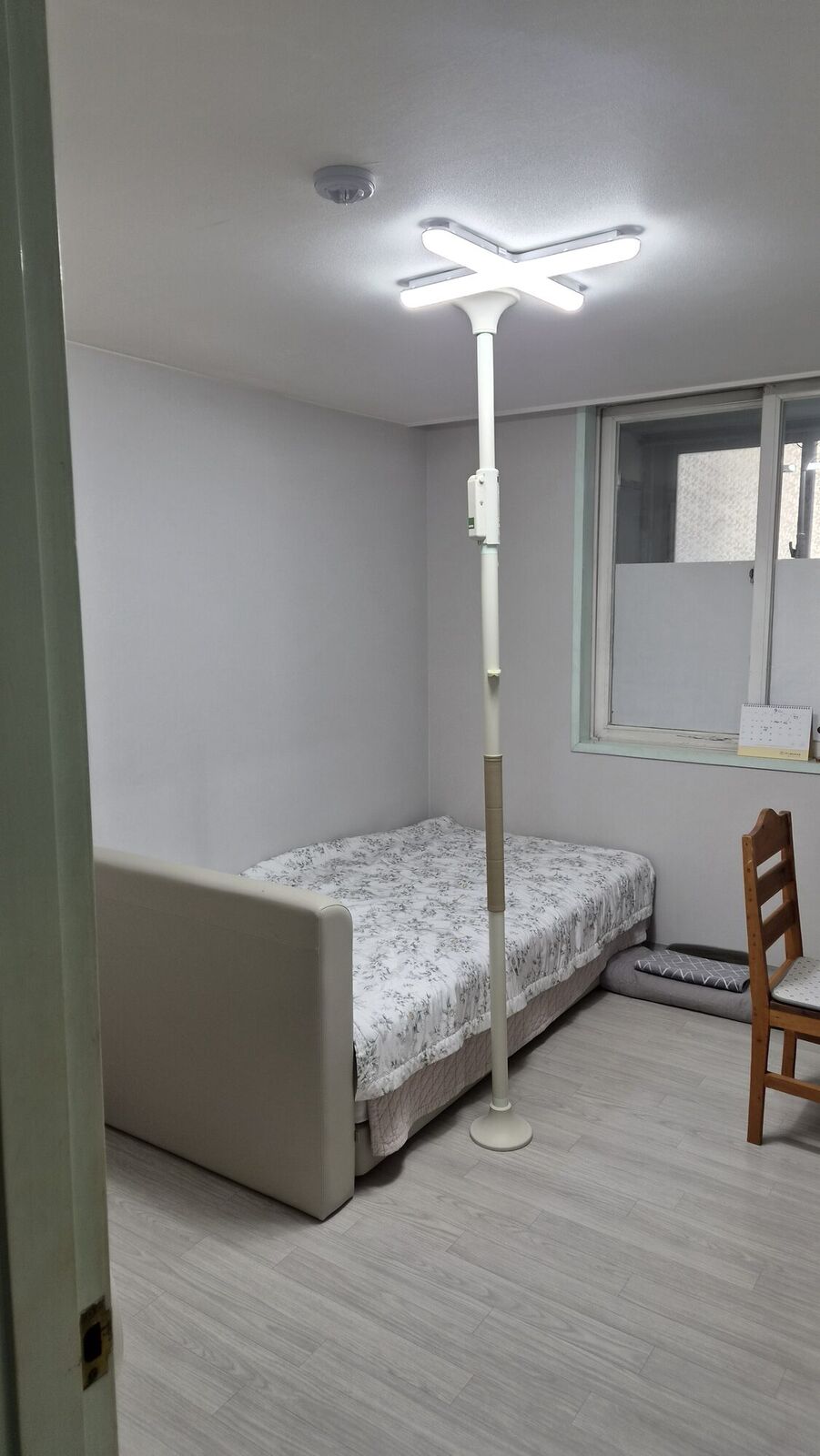 경남 재가복지와 함께 안내하는 복지용구 참고사진 - 침대 옆 바닥과 천장 사이에 고정한 기둥형 안전손잡이